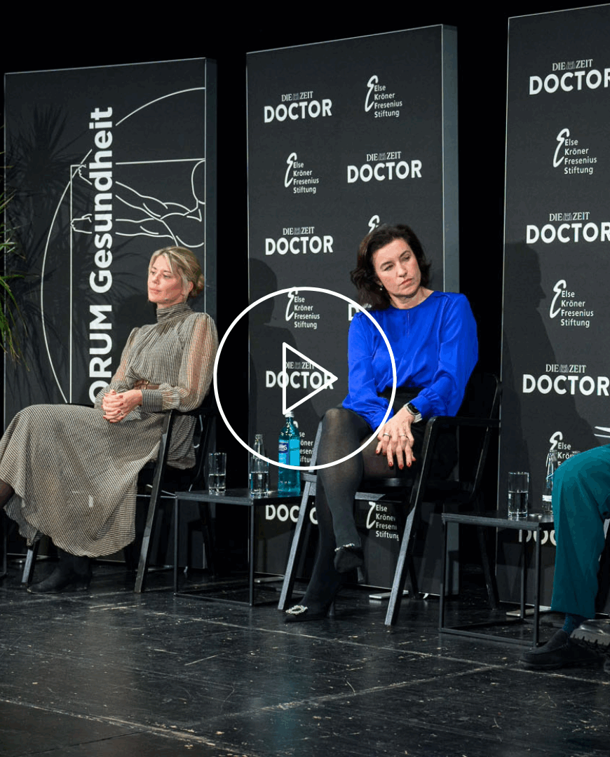 Auf dem Podium diskutieren Kai Zacharowski, Judith Bildau, Dorothee Bär, und Getraud Stadler (von links nach rechts). Es moderiert Nora Burgard-Arp. Alle sitzen vor schwarzen Rückwänden.