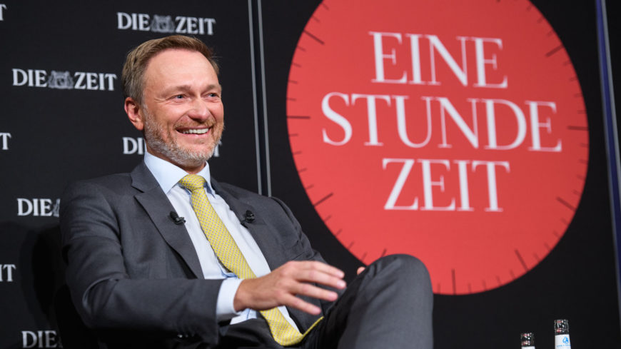 FDP-Politiker Christian Lindner sitzt lächelnd vor der Kulisse der Veranstaltung EINE STUNDE ZEIT von der Wochenzeitung DIE ZEIT.